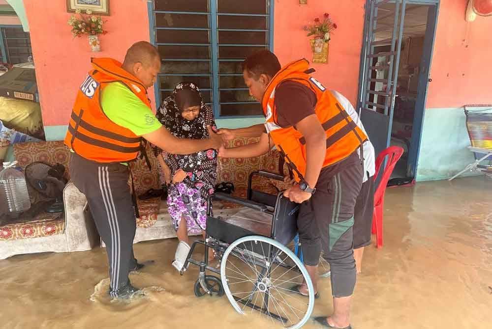 Anggota polis membantu memindahkan keluarga yang terperangkap akibat banjir di Kampung Parit Jepun, Ulu Benut Simpang Renggam, Kluang. Foto IPD Kluang