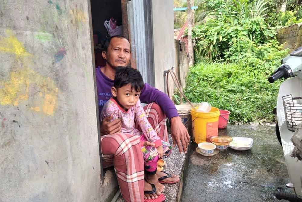Abdul Mukmin bersama seorang anak bongsunya yang berusia lima tahun.