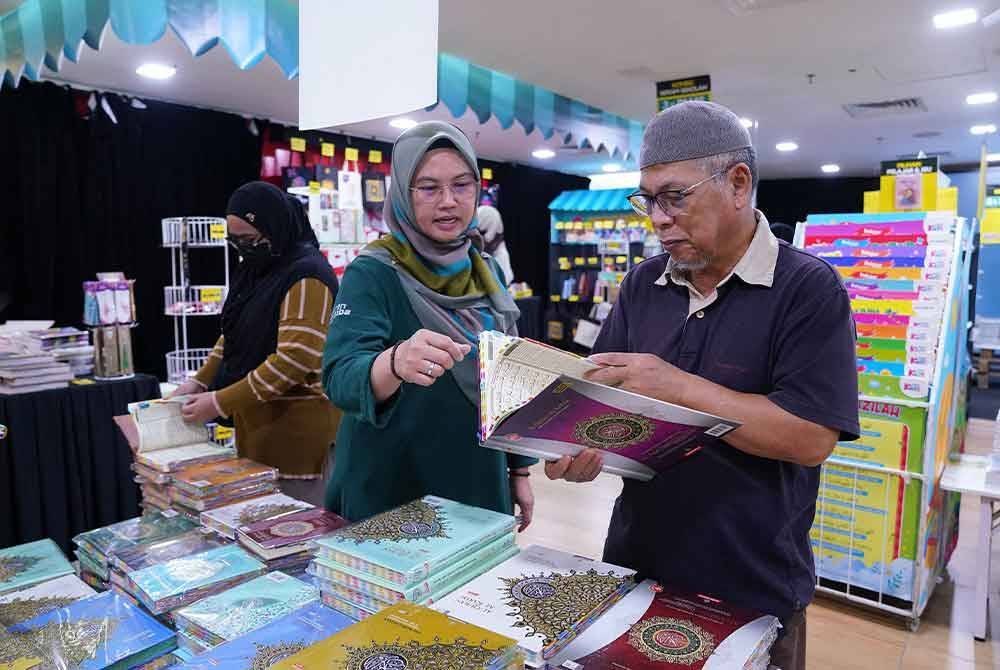 Salah seorang petugas sedang melayani pengunjung yang berminat membeli al-Quran.