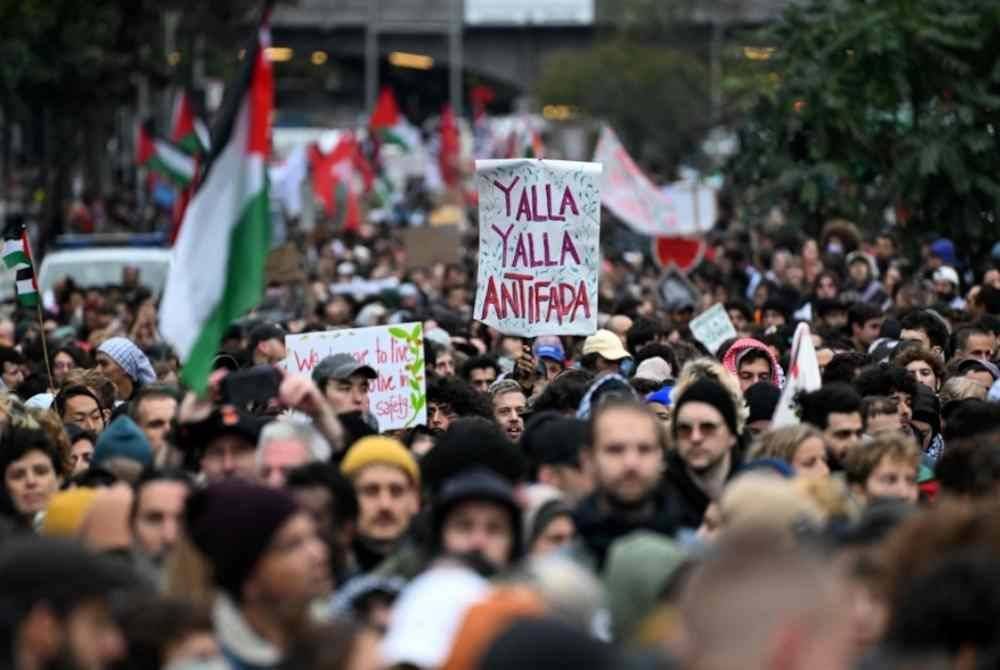 Para peserta berarak semasa 'Demonstrasi menentang pembunuhan beramai-ramai di Gaza' berhampiran dataran Kottbusser Tor di daerah Kreuzberg di Berlin. Foto AFP