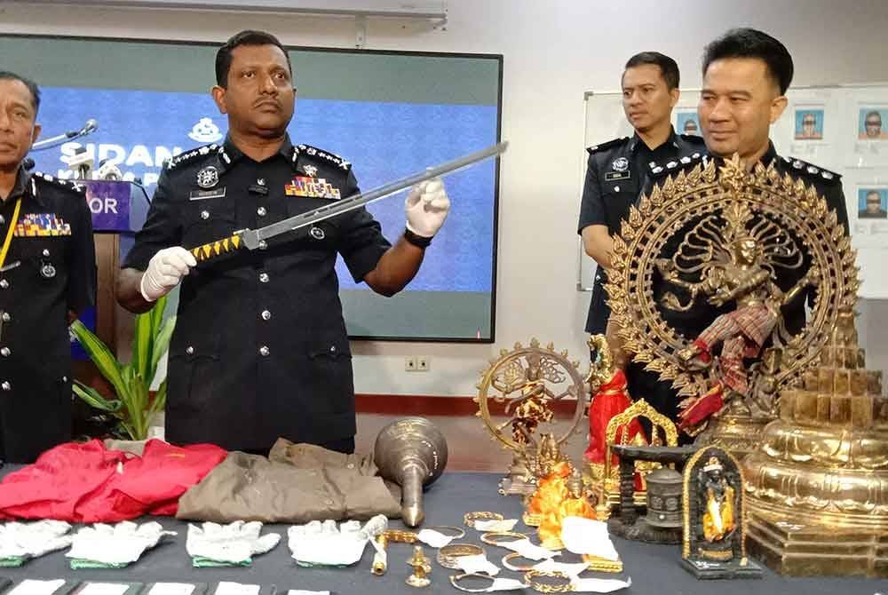 Hussein (tengah) memegang parang panjang yang digunakan kumpulan penjenayah terbabit ketika melakukan jenayah samun.