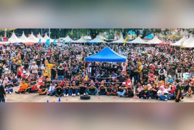 Fadzli (tengah) bersama ribuan peminat pemotoran bergambar kenangan di Dataran Temerloh pada Ahad.