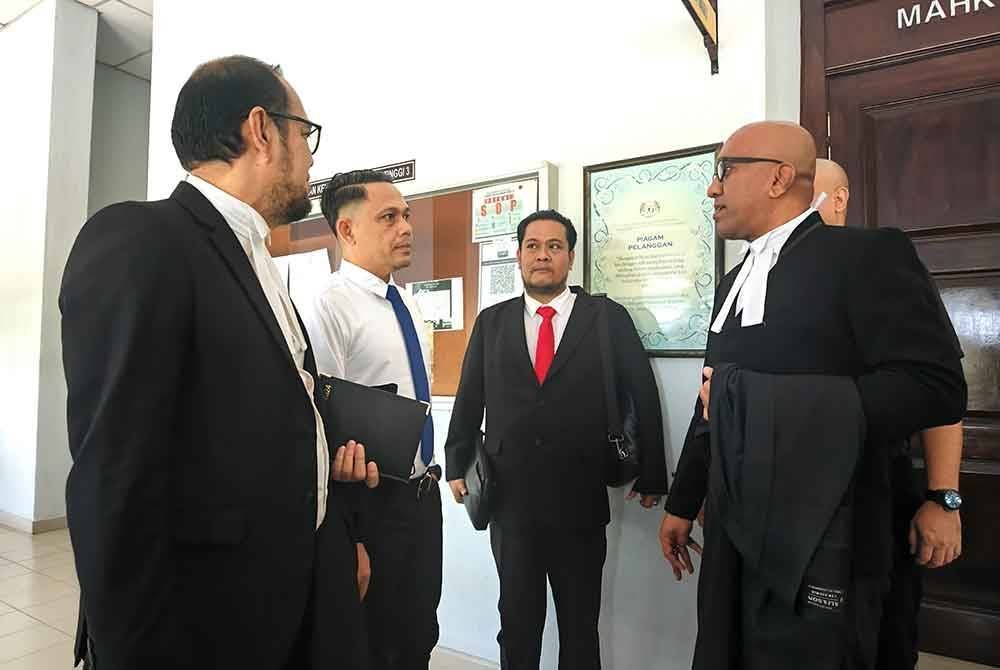 Roslan (dua dari kiri) bertemu Haresh (kanan) dan Ramzani (kiri) di luar mahkamah.