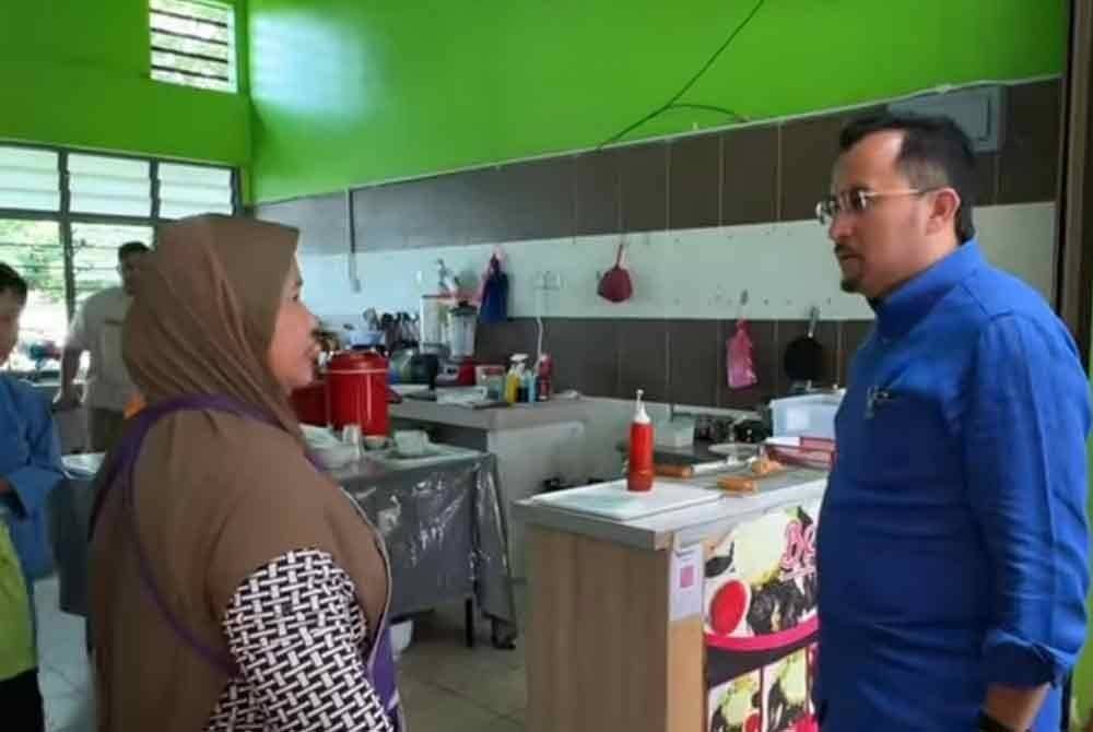 Dr Asyraf Wajdi (kanan) berbual dengan salah seorang penyewa lot di Arked Mara di Pekan Changlun.