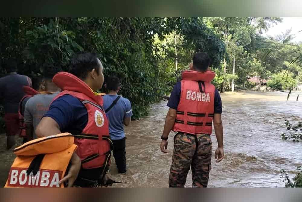 Anggota bomba melakukan kerja-kerja menyelamat mangsa yang terjejas banjir di Kampung Banggol Deram, Baling, Kedah. FOTO JBPM