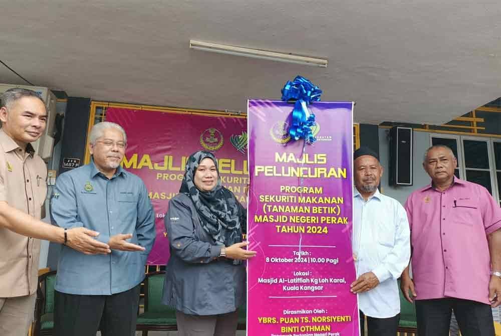Norsiyenti (tiga dari kiri) menyempurnakan gimik Peluncuran Program Sekuriti Makanan (tanaman betik) Masjid Negeri Perak di Masjid Al Lattifiyah Kampung Loh, Karai pada Selasa.