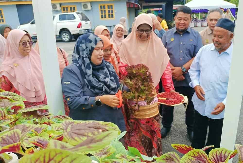 Norsiyenti menunjukkan sayur bayam hasil kaedah tanaman hidroponik yang dilaksanakan Masjid Al Lattifiyah Kampung Loh, Karai.
