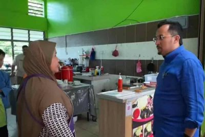 Dr Asyraf Wajdi (kanan) berbual dengan salah seorang penyewa lot di Arked Mara di Pekan Changlun.