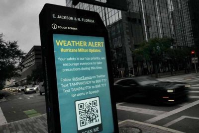 Amaran cuaca dipaparkan di sepanjang kaki lima ketika Taufan Milton bergelora di Teluk Mexico pada Isnin di Tampa, Florida. - Foto: AFP