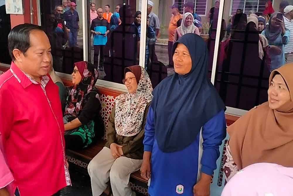 Ahmad (dua kiri) bertanya khabar mangsa banjir di PPS Sekolah Kebangsaan Seri Anom, Sanglang, Pontian.