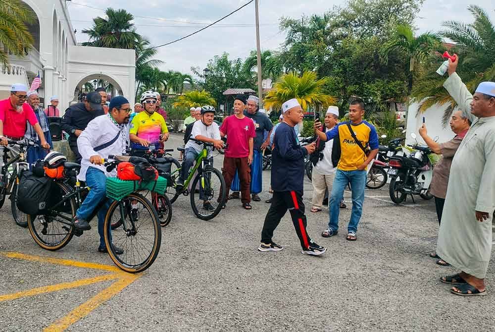 Pelepasan kembara Ahmad Zulkifle oleh Setiausaha masjid, Zulkanain Hashim (kanan) di pekarangan masjid pada Rabu.