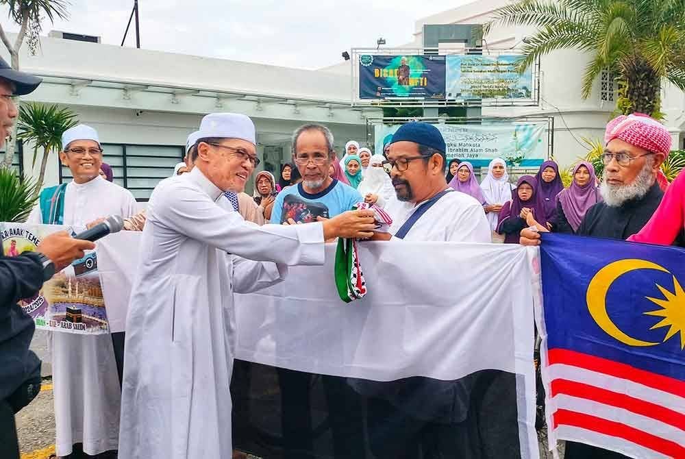 Abdullah (dua dari kiri) turut menyerahkan sumbangan masjid kepada Ahmad Zulkifle (tiga dari kanan)