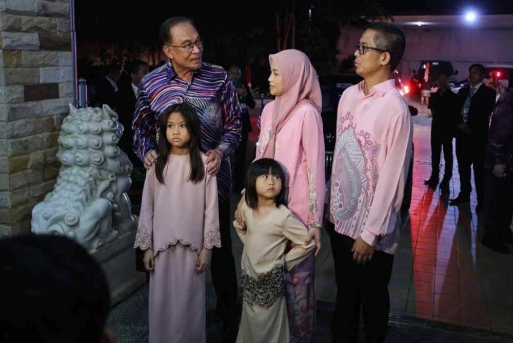 Anwar (kiri) berbual bersama Duta Besar Malaysia ke Laos, Edi Irwan (kanan) dan keluarganya ketika meluangkan masa bersama delegasi Malaysia pada majlis makan malam sempena Sidang Kemuncak ASEAN ke-44 dan ke-45 pada malam Rabu.