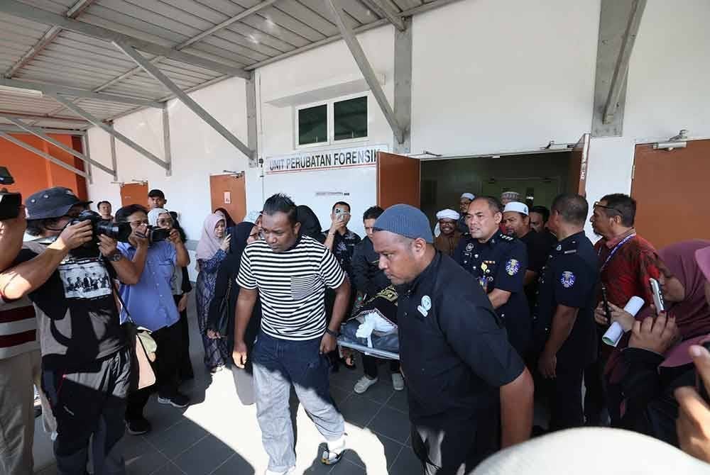 Jenazah mangsa dibawa keluar dari unit forensik Hospital Dungun sebelum dibawa ke Masjid UiTM Dungun untuk disembahyangkan.