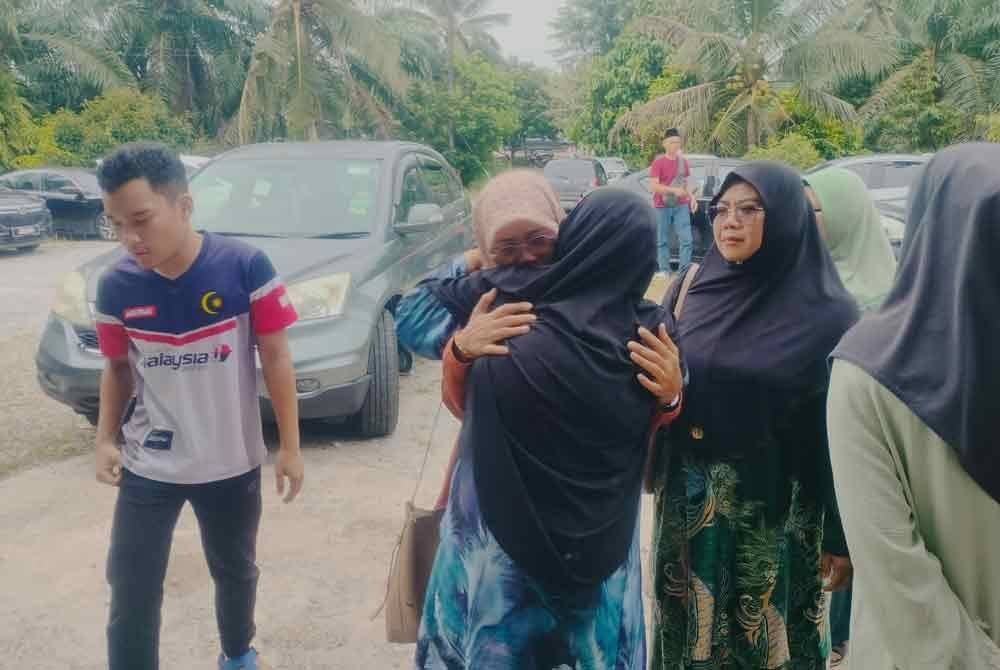 Ibu Muhammad Akmal, ditenangkan suadara mara sebaik tiba di Kampung Parit Baru, Muar pada petang Khamis.