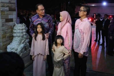 Anwar (kiri) berbual bersama Duta Besar Malaysia ke Laos, Edi Irwan (kanan) dan keluarganya ketika meluangkan masa bersama delegasi Malaysia pada majlis makan malam sempena Sidang Kemuncak ASEAN ke-44 dan ke-45 pada malam Rabu.