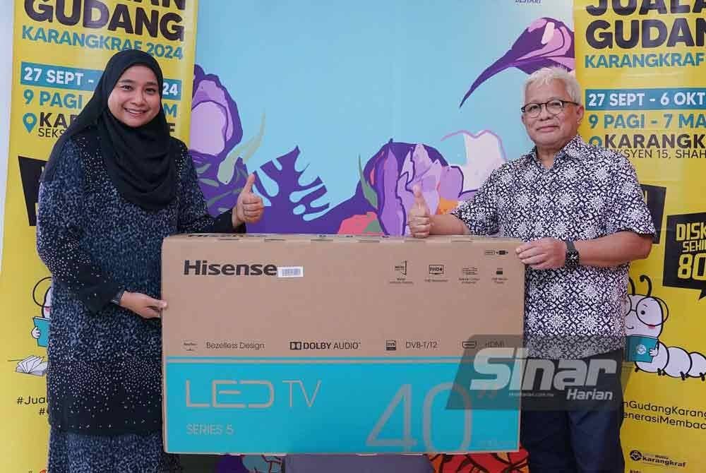 Malini (kiri) menerima hadiah berupa televisyen LED 40 inci daripada Penasihat Kumpulan Karangkraf, Datuk Hussamuddin Yaacub di Kompleks Kumpulan Karangkraf, di sini pada Khamis. Foto Sinar Harian/ MOHD HALIM ABDUL WAHID.
