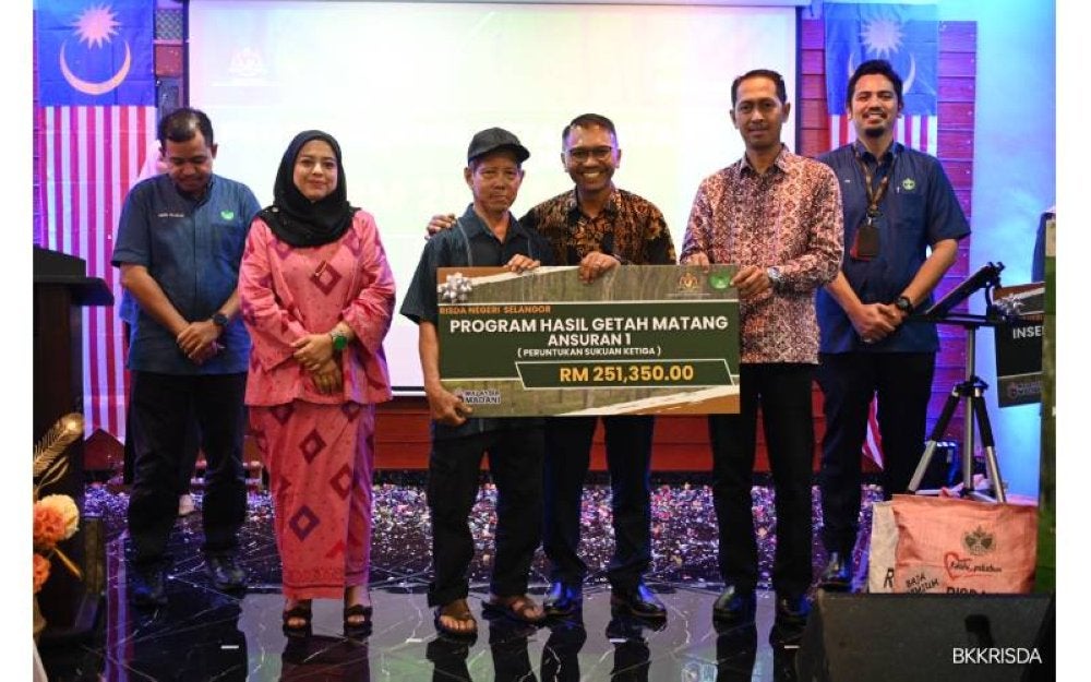 Md Najip (tiga, kanan) bemenyampaikan bantuan kepada salah seorang pekebun kecil getah di Selangor.