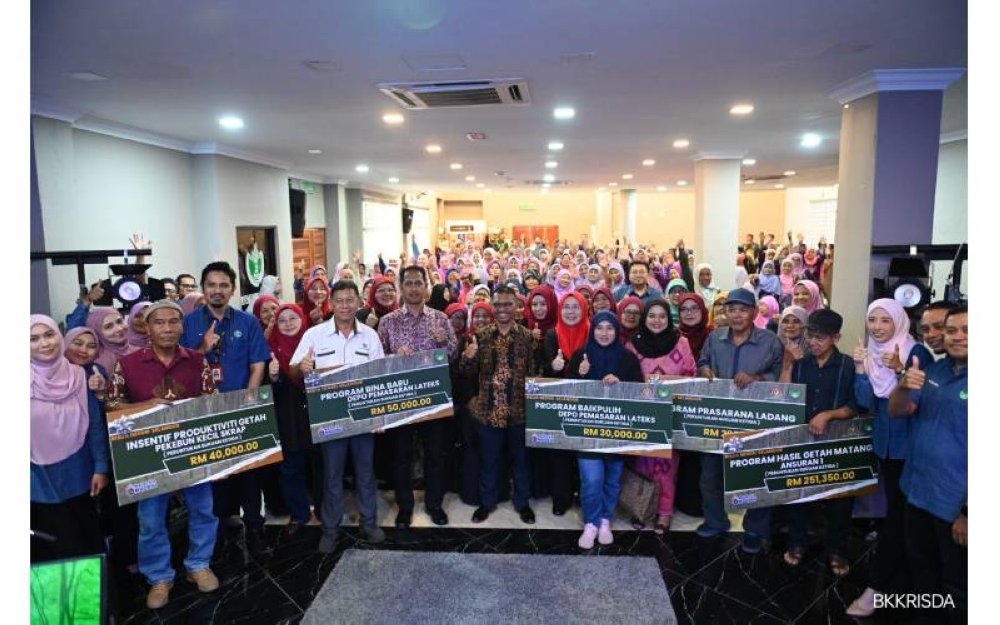 Md Najip (tengah) bersama para penerima bantuan RISDA.