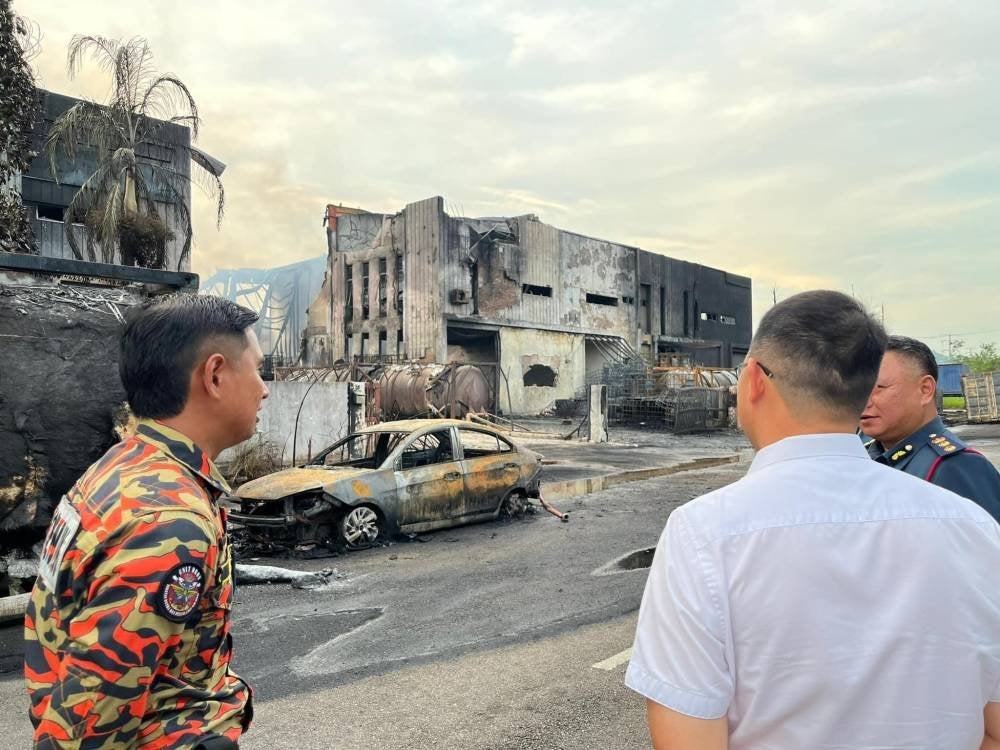 Tian Soon (tengah)mendengar taklimat ketika melawat ke lokasi kebakaran.