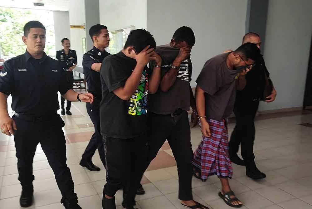 Muhammad Ilyas (kanan) dan Muhammad Khalid (kiri) diiring polis ketika hadir ke mahkamah.