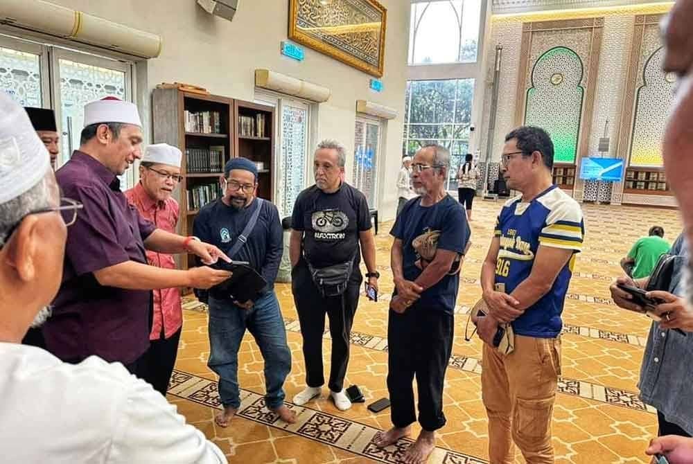 Syed Ibrahim (dua dari kiri) memberikan kata-kata semangat dan nasihat kepada Ahmad Zulkifle (empat dari kanan) dan peserta kembara lain.