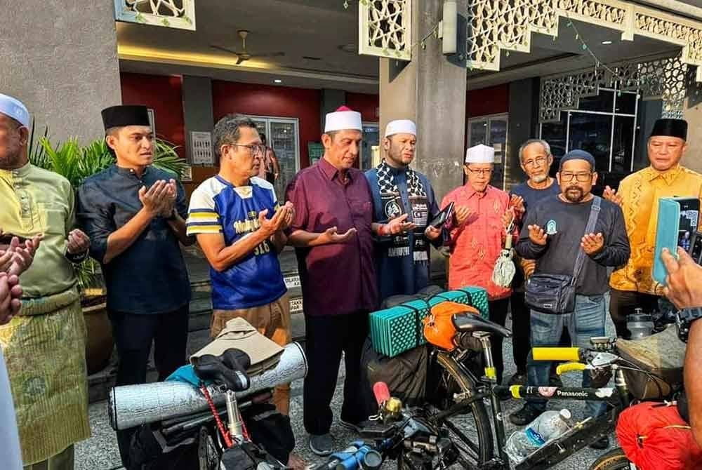 Syed Ibrahim (enam dari kanan), Ahmad Zulkifle (dua dari kanan) dan Abdullah (tiga dari kanan) berdoa sempena kembara tersebut di Masjid Kampung Baru, Kuala Lumpur pada Khamis.