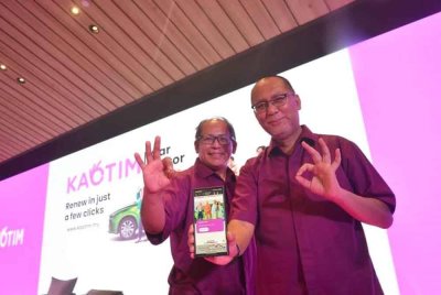 Nor Azman (kanan) dan Mohamed Sabri menunjukkan pelan perlindungan Kaotim Car dan Kaotim Motor yang boleh dimohon melalui dalam talian.