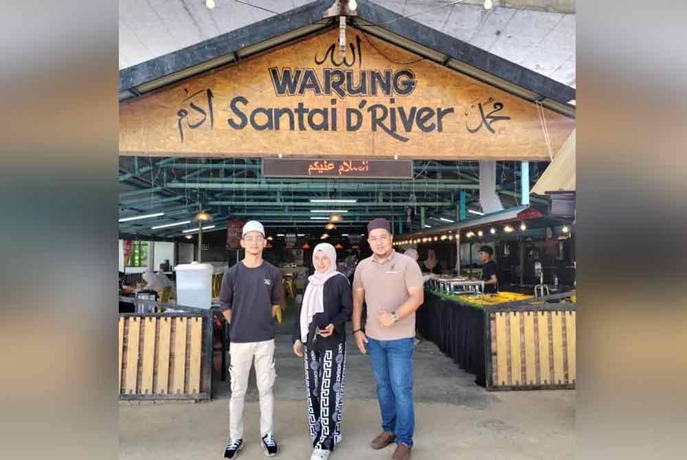 Abdul Mutalib (kanan) bergambar di hadapan Warung Santai D' River.