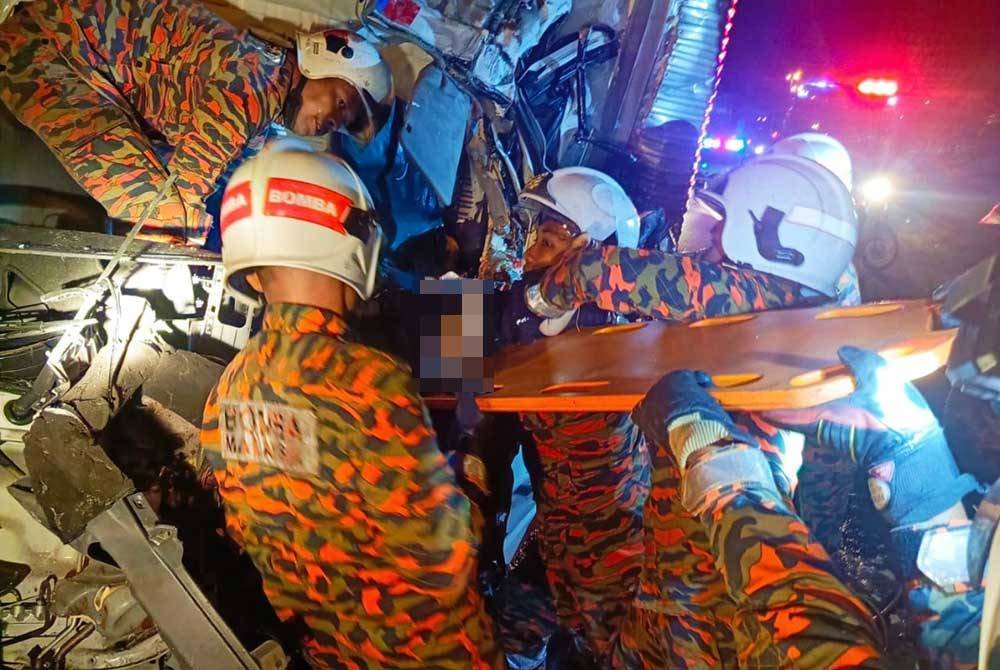 Anggota bomba mengeluarkan mangsa yang tersepit di bahagian tempat duduk hadapan. Foto JBPM Perak