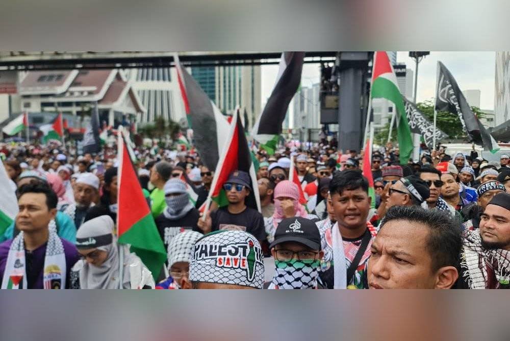 Peserta 'Himpunan Setahun Gaza, Demo Mega’ berarak dari Masjid KLCC hingga ke Jalan Tun Razak berhampiran Kedutaan AS bagi menyatakan solidariti terhadap Palestin.