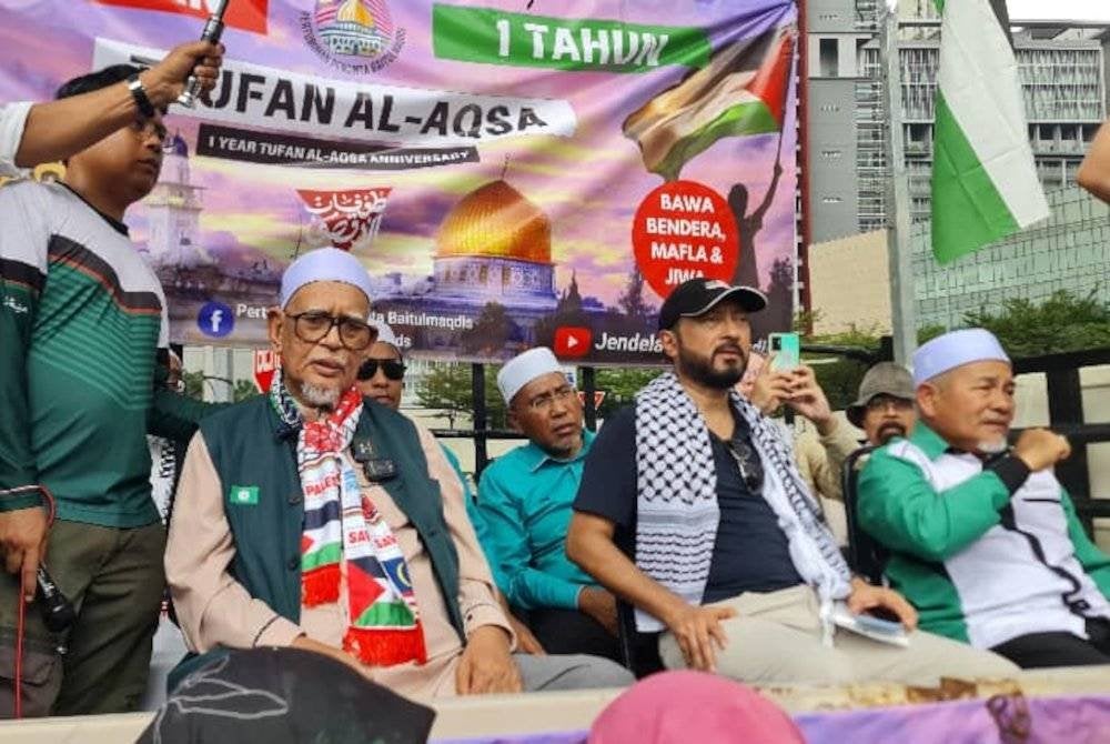 Abdul Hadi (kiri) hadir menyampaikan ucapan pada 'Himpunan Setahun Gaza, Demo Mega’ berhampiran Kedutaan AS di Jalan Tun Razak pada Sabtu.