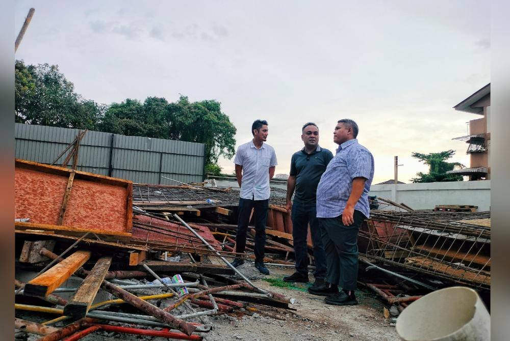 Rais (kanan) meninjau lokasi bangunan runtuh hingga mengakibatkan seorang maut di Jalan Bukit Senjuang di sini, pada petang Sabtu.