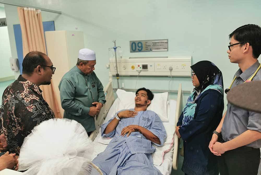 Maliaman (dua dari kiri) melawat Muhammad Ammar Danish yang dirawat di Hospital Dungun pada Ahad.