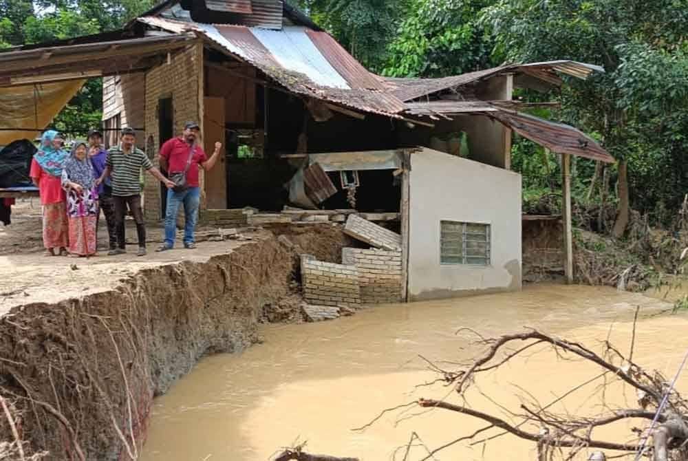 Penduduk menunjukkan keadaan sebuah rumah yang runtuh akibat hakisan dan banjir di Kampung Batu 60, Tanjung Pari, Baling, Kedah.