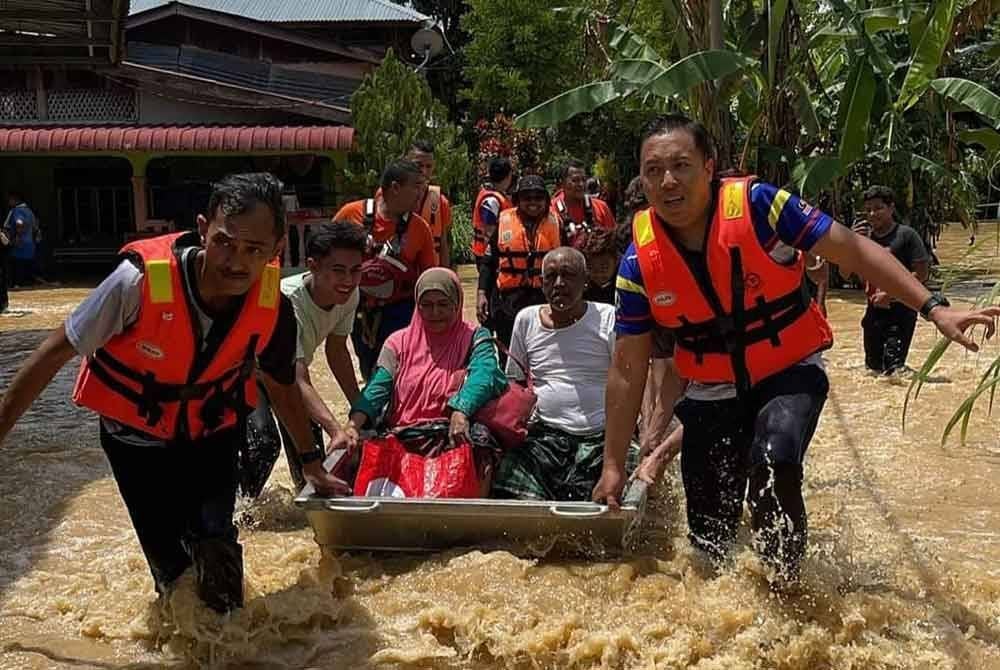 Anggota APM Kedah menyelamatkan mangsa terjejas banjir. Foto APM