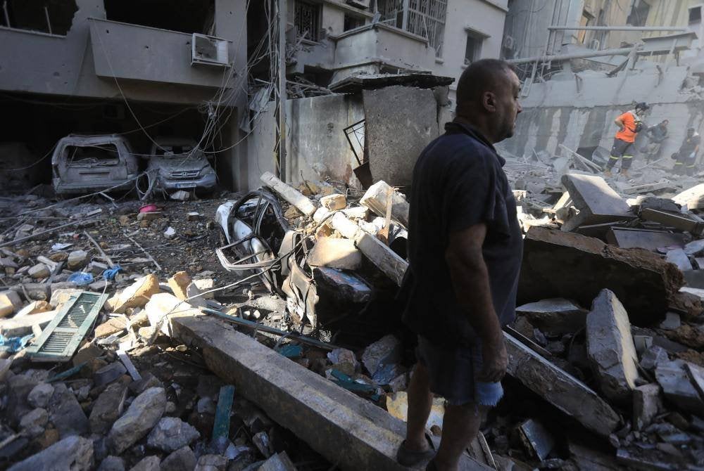 Penduduk meninjau runtuhan bangunan di tapak serangan Israel ke atas kejiranan Basta di Beirut. Foto AFP