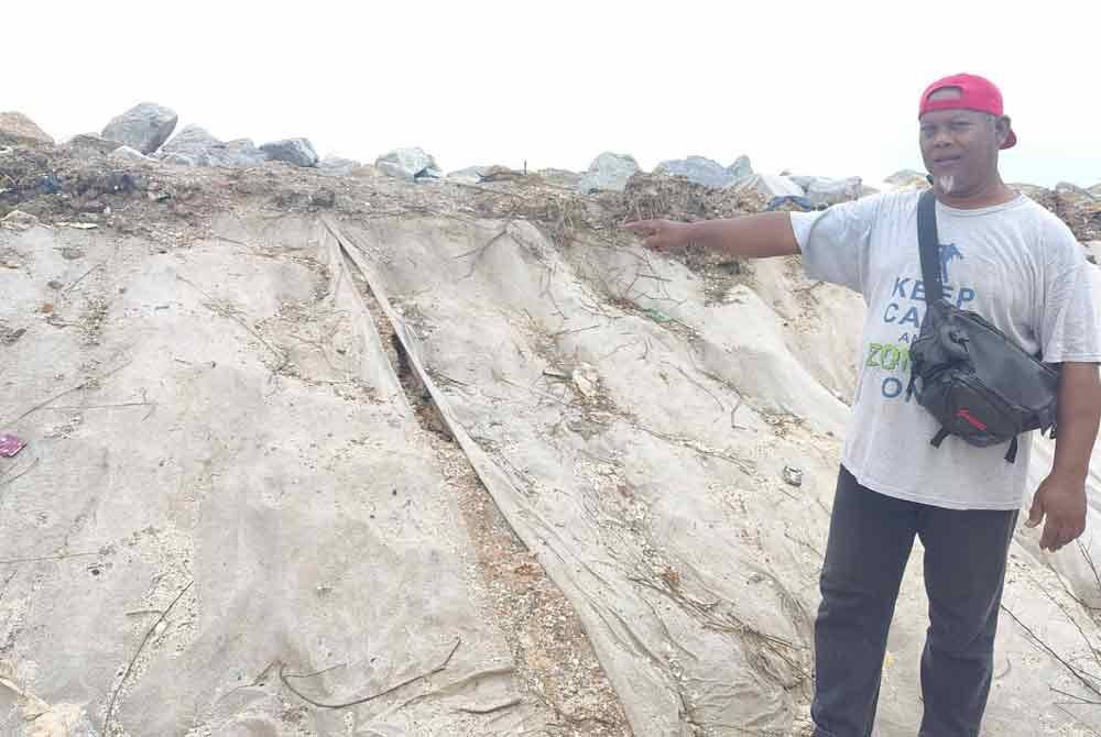 A Rahim menunjukkan benteng penahan ombak di Kampung Baru Lembah Pantai, Sungai Kajang, Tanjong Karang di sini.