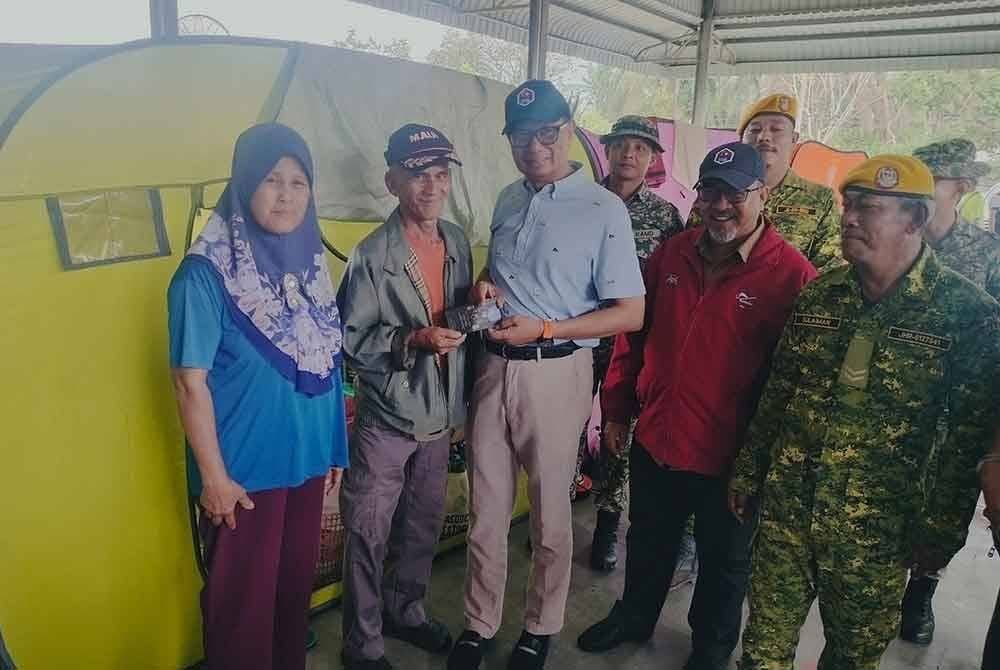 Samsolbari (tiga dari kanan) menyerahkan sumbangan kepada Mohamad di PPS SK Seri Bunut.