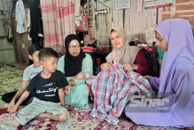 Roslaiti (dua dari kanan) memegang baju milik Adnan.