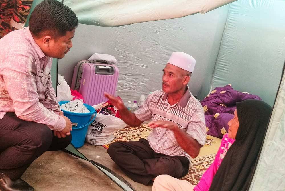 Mohd Hasbie (kiri) mendengar pengalaman yang dihadapi mangsa banjir, Isnin Yusof, 60, dan isterinya, Shamsiah Bakhtiar, 56, ketika lawatannya ke PPS SMK Seri Semantan.