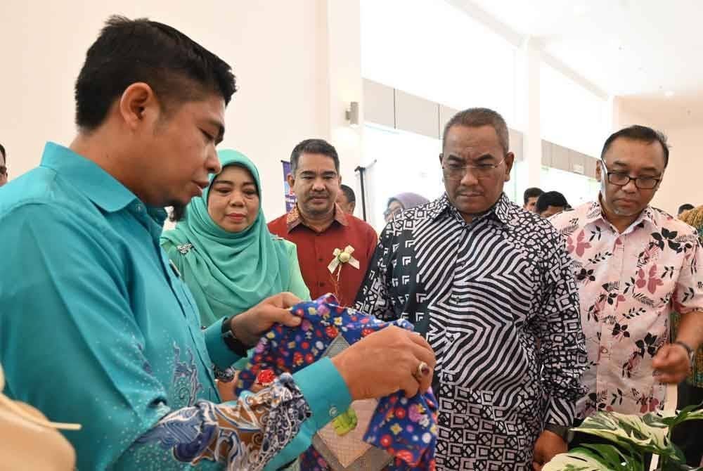 Sanusi (dua dari kanan) melawat ruang pameran yang mempamerkan pelbagai produk sempena sambutan Hari Kanak-kanak, Hari Orang Kurang Upaya dan Hari Warga Emas peringkat negeri.
