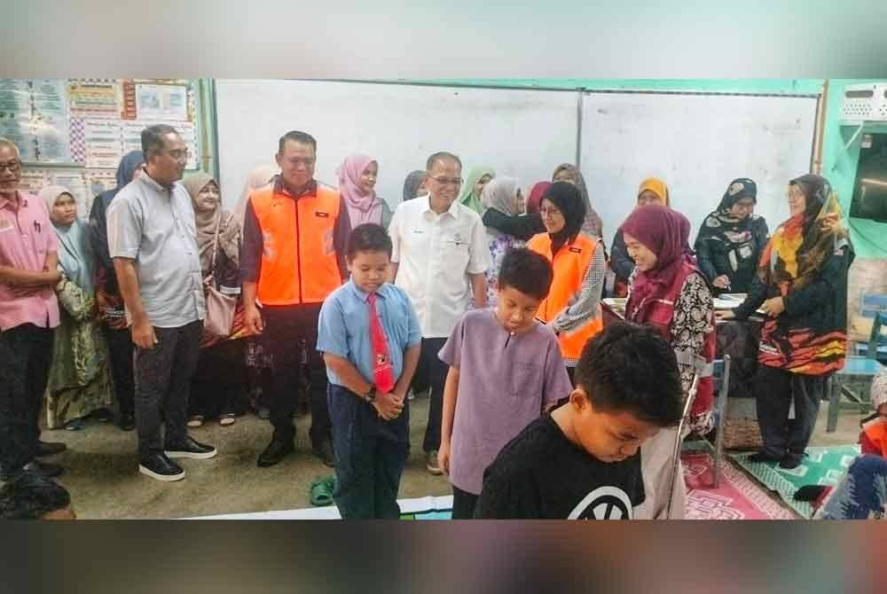 Wan Rosdy (tengah) melihat kanak-kanak yang meluangkan masa dengan permainan yang disediakan di PPS terbabit.