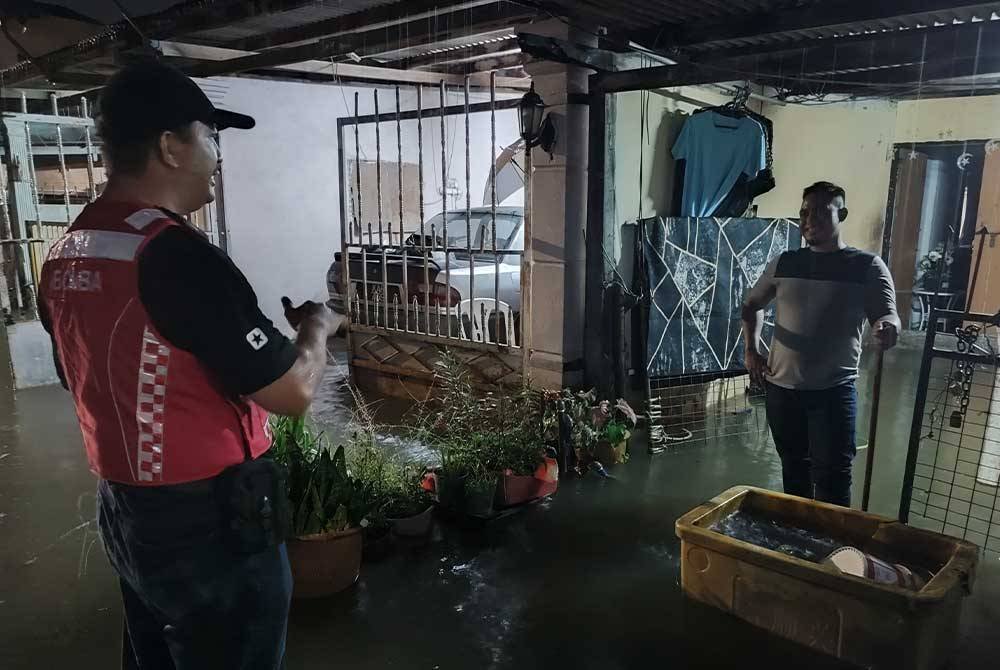 Wan Mohd Hamizi (kiri) melakukan pemantauan di sekitar Taman Sri Putra, di sini, pada awal pagi Jumaat.