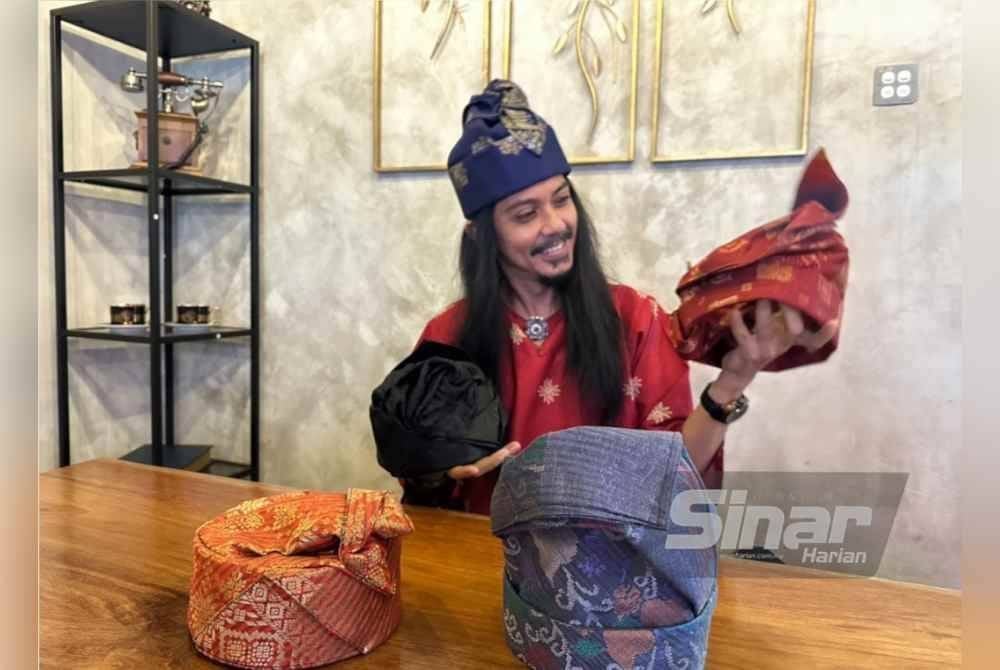 Mohamad Edry Sham menunjukkan tanjak kreasi Getam Naga di tangan kirinya dan Sireh Acheh di tangan kanan.