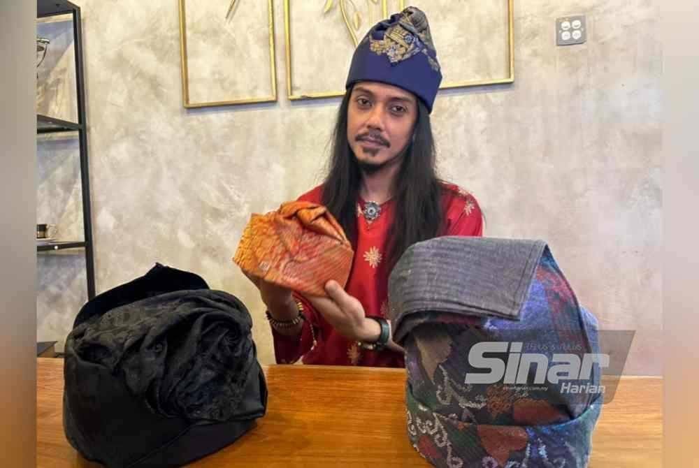 Mohamad Edry Sham memakai dan memegang tanjak jenis Getam Budur.