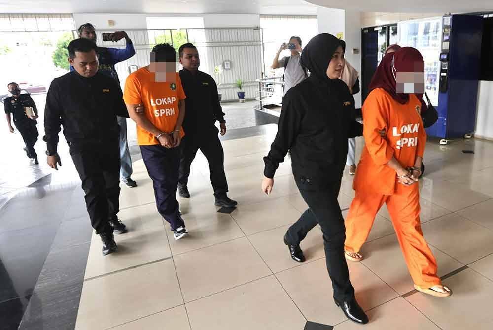 Dua pegawai penguatkuasa tiba di Kompleks Mahkamah George Town pada pagi Sabtu.