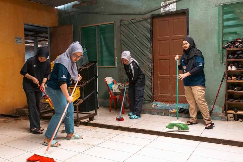 Beberapa kakitangan membersihkan kawasan yang terkesan banjir.