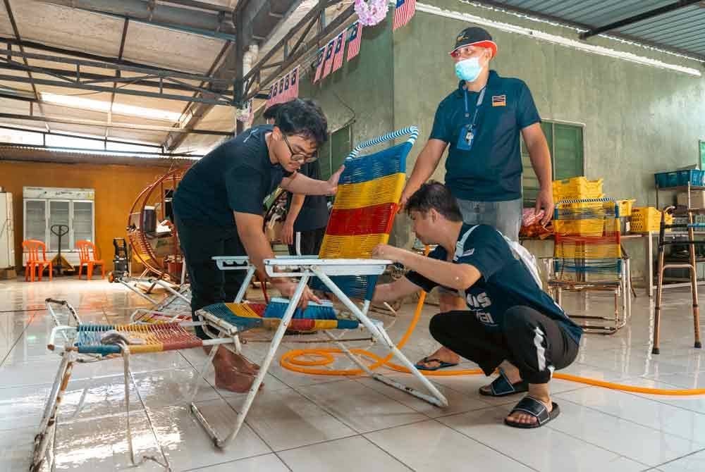 Kakitangan bertugas turut membantu membersihkan kerusi yang terkesan akibat banjir yang melanda kawasan di Kuala Selangor baru-baru ini.