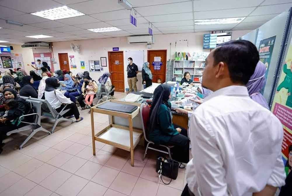 Onn Hafiz ( kanan) melihat keadaan ruang menunggu yang sesak dengan pesakit di Klinik Kesihatan Gelang Patah. Foto Facebook Onn Hafiz Ghazi